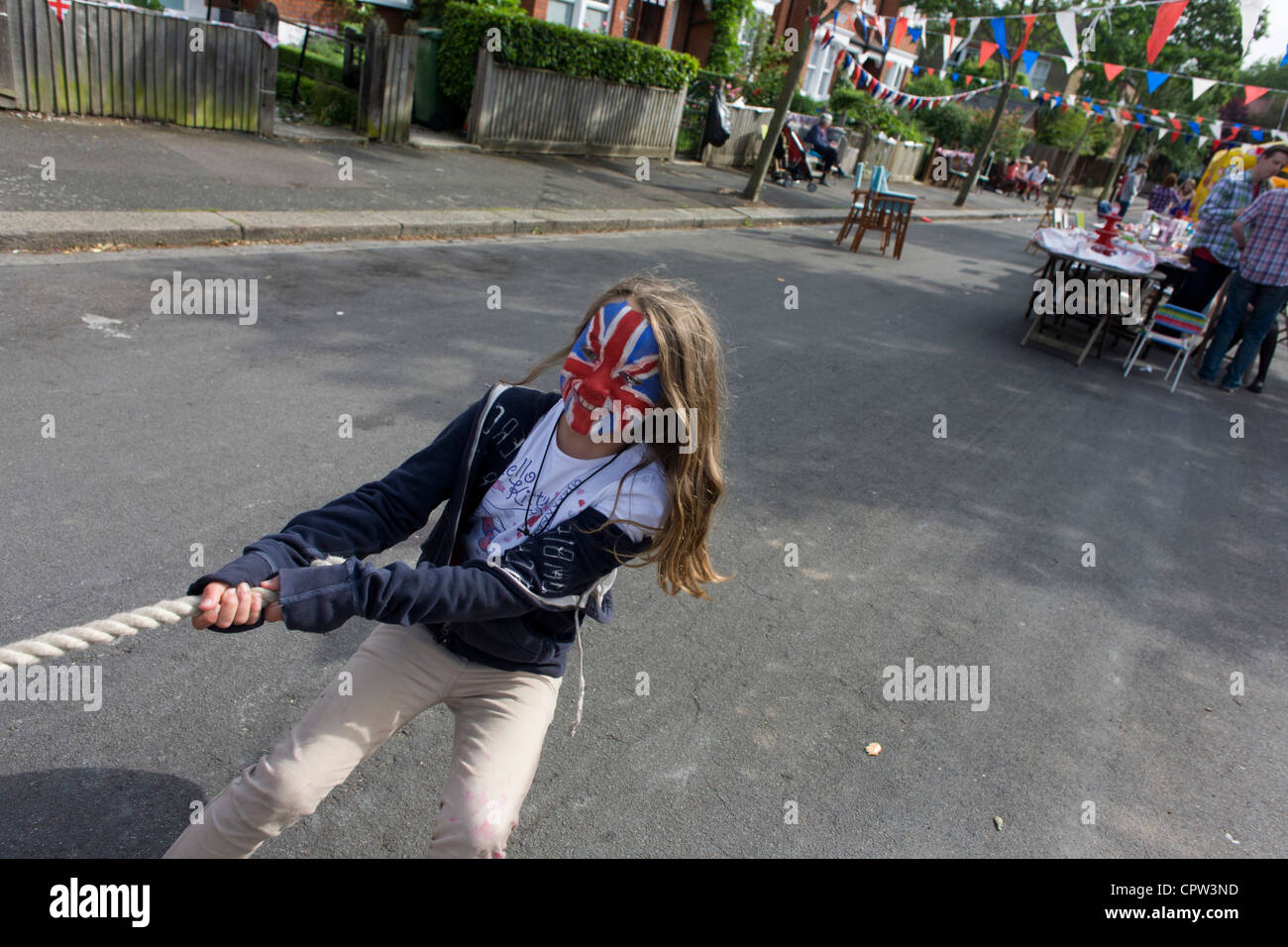 Girl with painted Union Jack face pulls during tug-o-war game at a  neighbourhood street party in Dulwich, south London celebrating the Diamond  Jubilee of Queen Elizabeth Stock Photo - Alamy