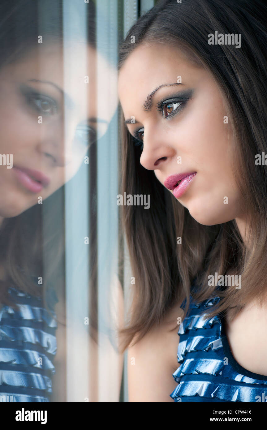 girl smiling through the window, after a rain. Portrait. Stock Photo