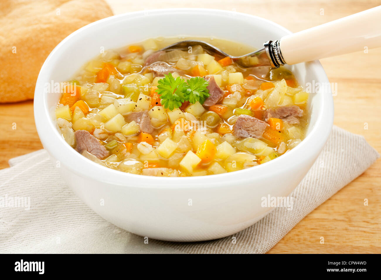 A bowl of bubbling hot Scotch Broth or Vegetable Soup, made from lamb shank, potato,carrot,celery,dried peas and pearl barley. Stock Photo