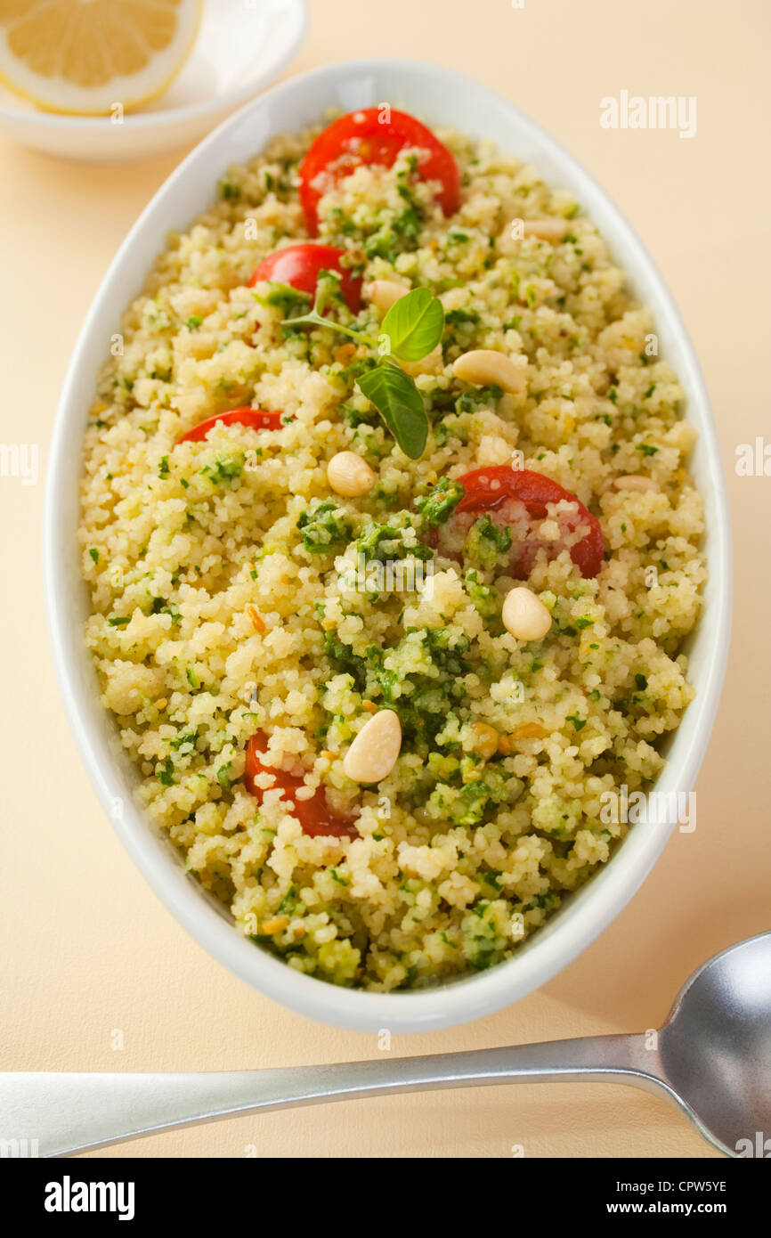 Couscous salad with spinach pesto and tomato. Stock Photo