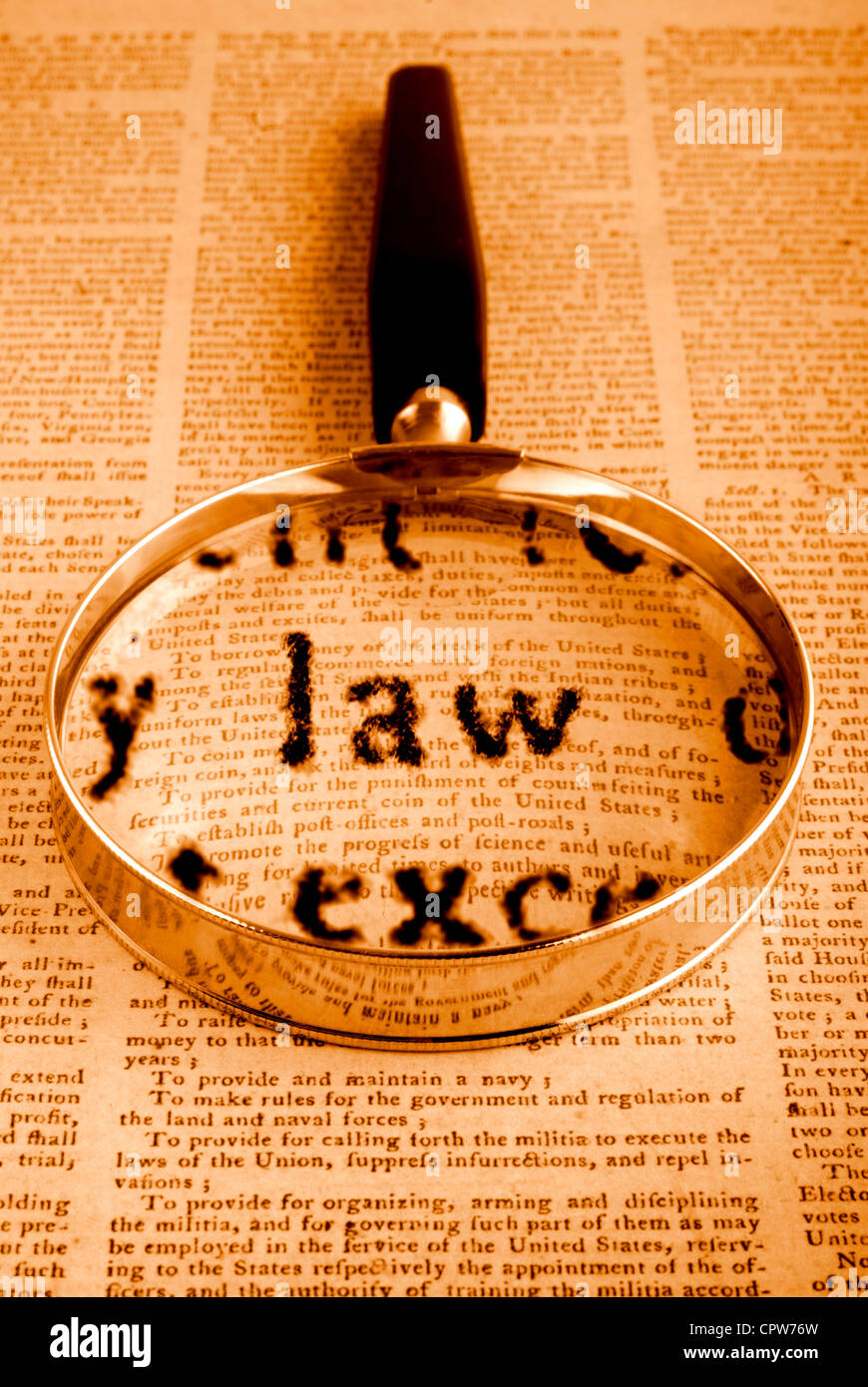 Magnifying glass on American Constitution, the word Law is emphasised, from the text. This is a very textured paper. Stock Photo