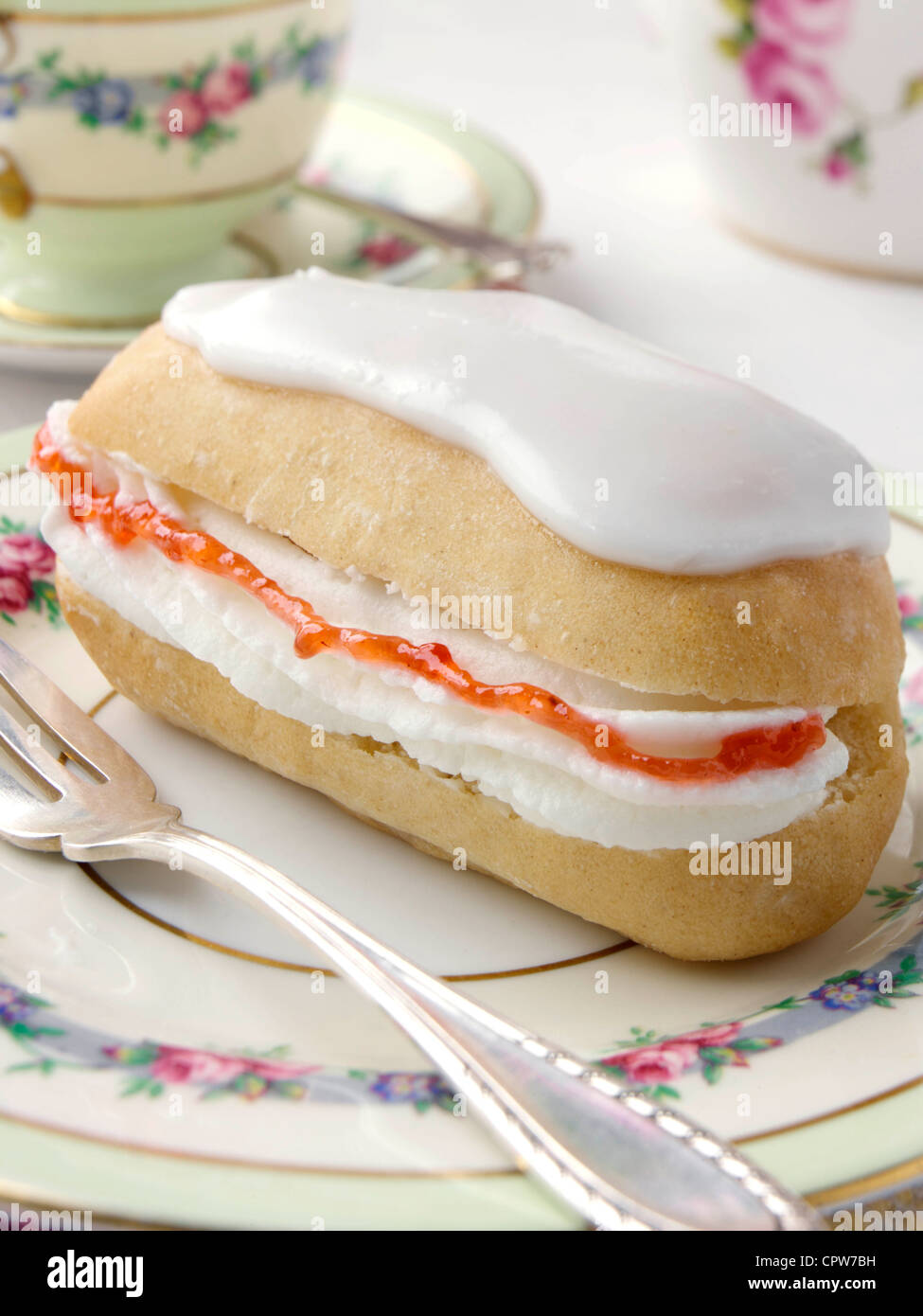 Strawberry jam cream filled iced finger bun hires stock photography