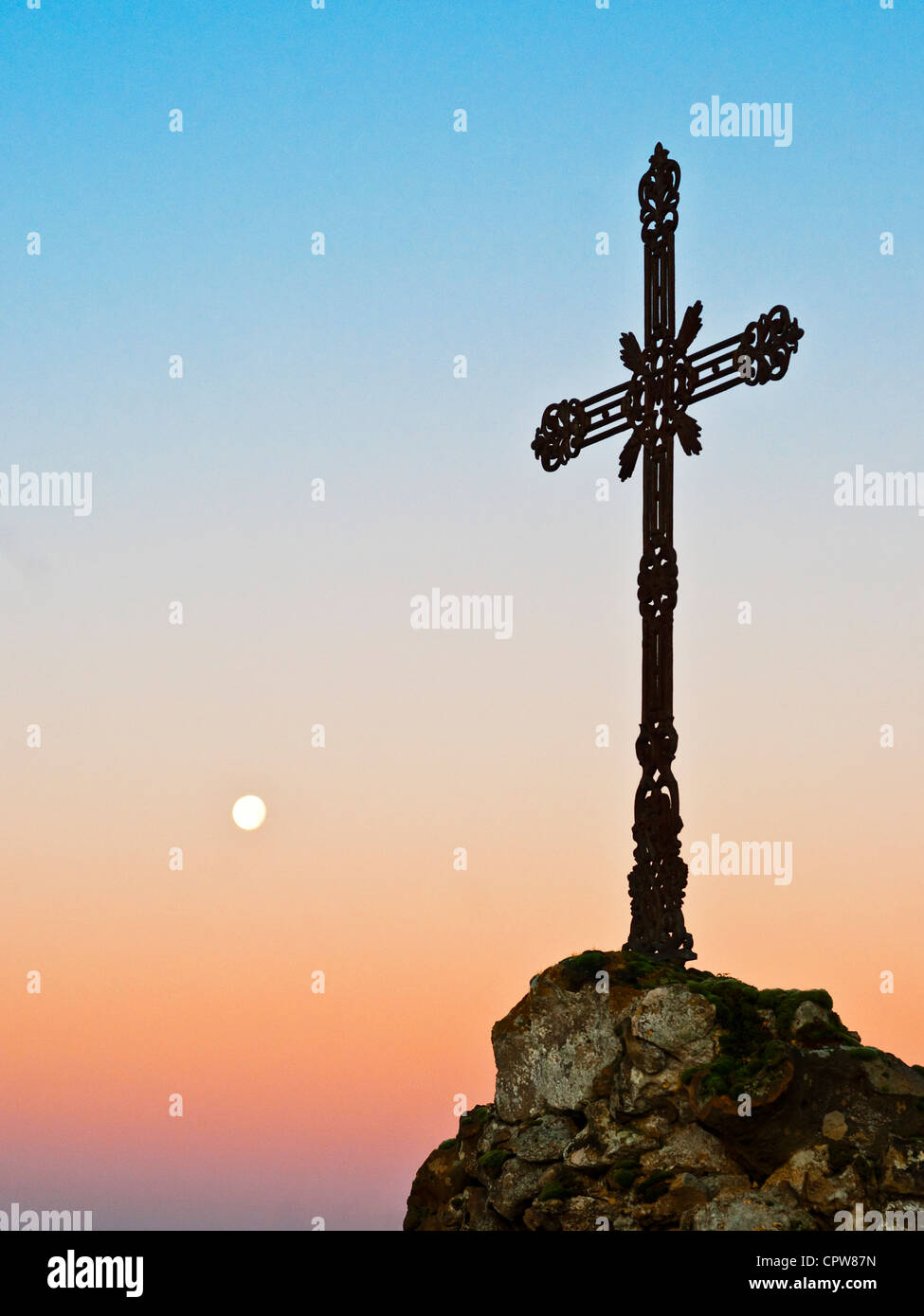 Cast iron cross and setting moon - France. Stock Photo