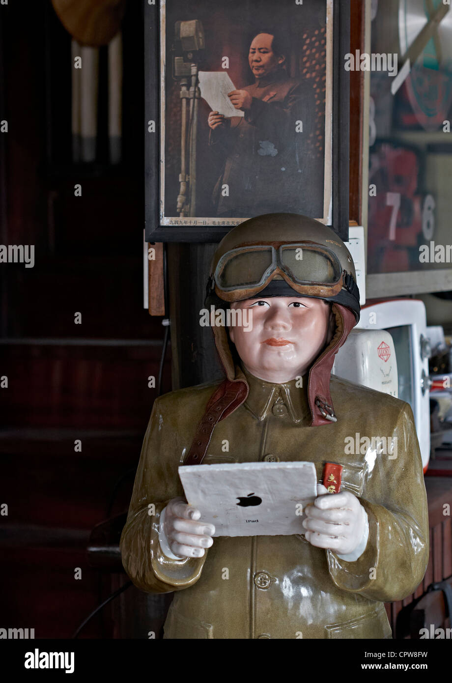 Amusing statue and appropriate equivalent image of Mao Tse Tung Zedong apparently realising the way forward with an iPad tablet Stock Photo