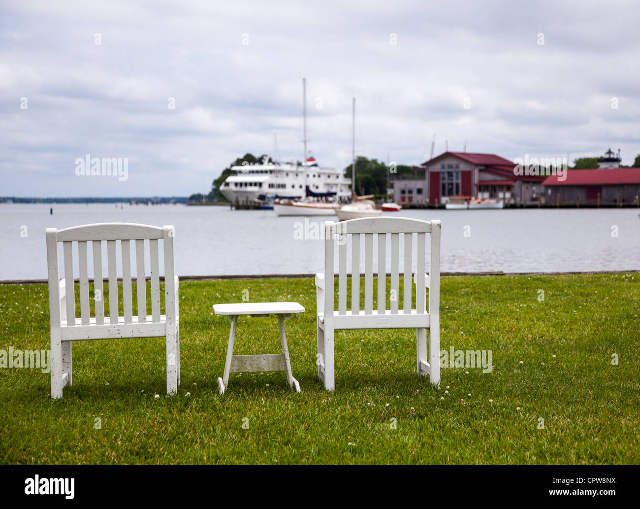 Empty patio chairs by side of the Chesapeake bay overlooking St Michaels harbor Stock Photo