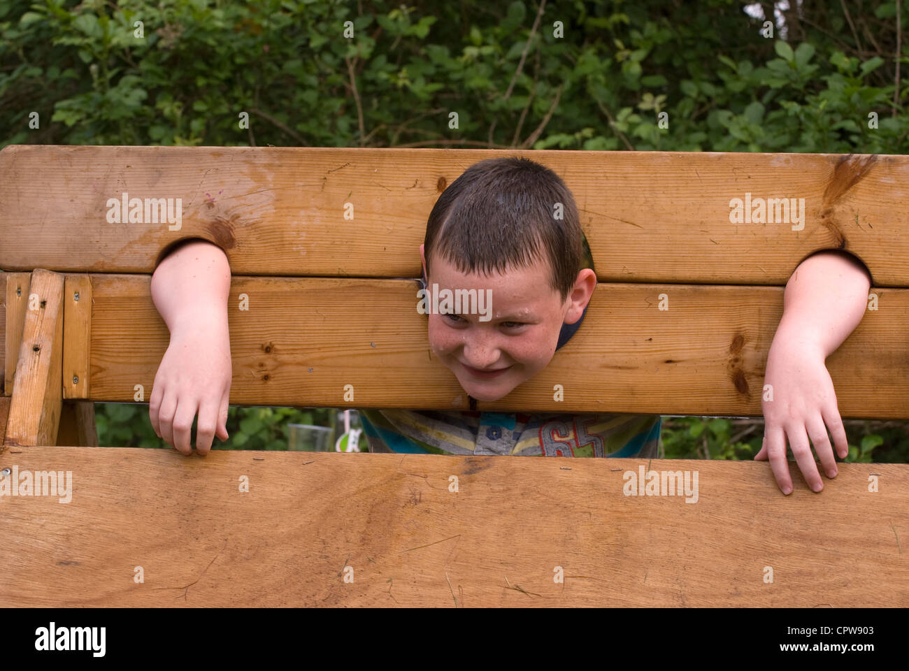 Young boy with head in the stocks being pelted with wet sponges at Dockenfield fete & Diamond Jubilee celebration day Stock Photo