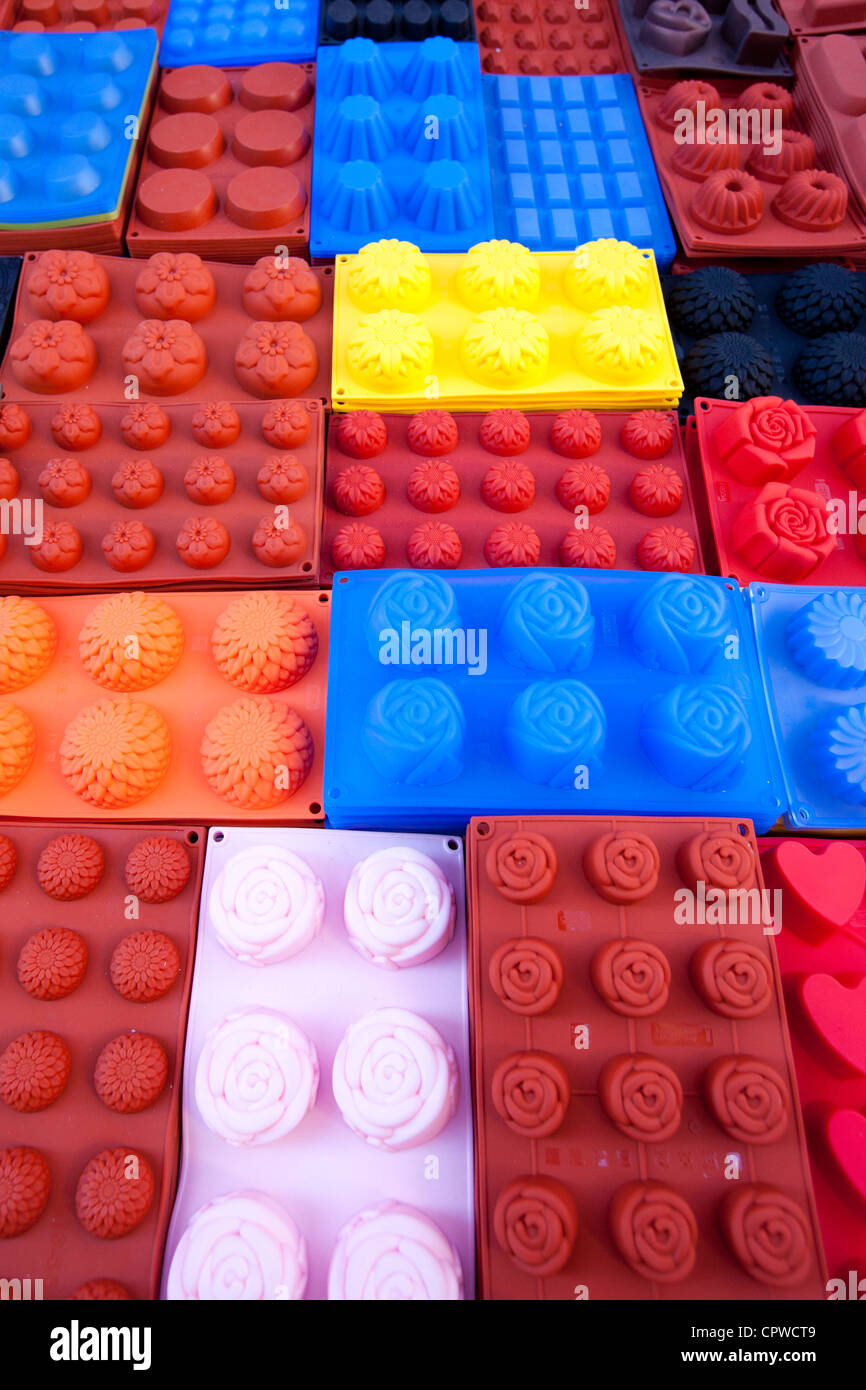 Silicone cake moulds in bright colours on sale at the market in Pienza, Tuscany, Italy Stock Photo