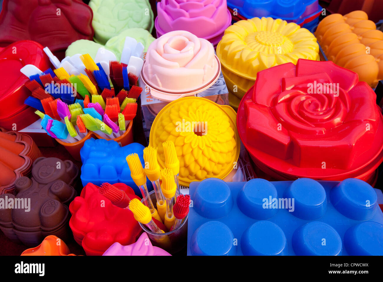 Silicone cake moulds in bright colours on sale at the market in Pienza, Tuscany, Italy Stock Photo