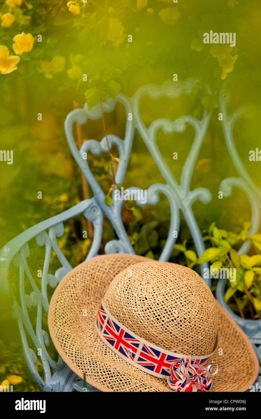 Lady's straw hat with Union Jack band in a country garden, England, UK