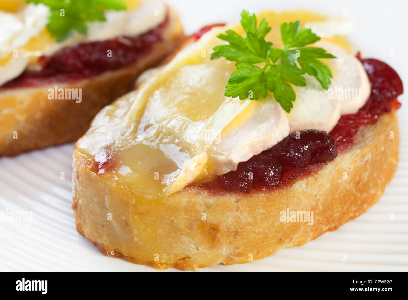 Chicken, brie and cranberry sauce, piled onto cheese bread and baked in the oven. A delicious snack! Stock Photo