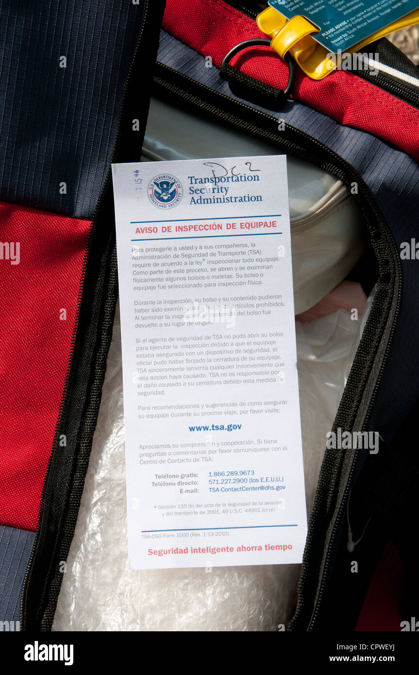 TSA having security searched this travelers bag leaves an advice note printed in Spanish USA Homeland Security Stock Photo