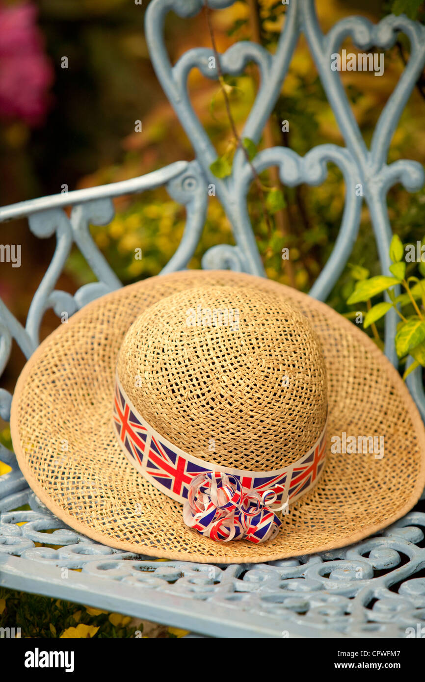 Lady's straw hat with Union Jack band in a country garden, England, UK