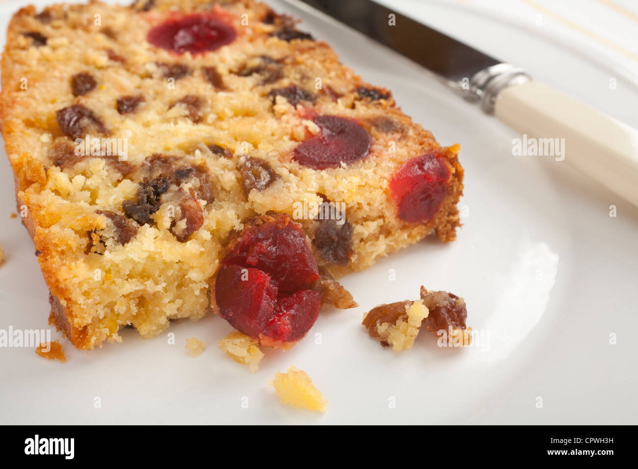 A slice of deliciously moist coconut fruit cake, stuffed with goodies like coconut, cherries, lemon and sultanas. Stock Photo