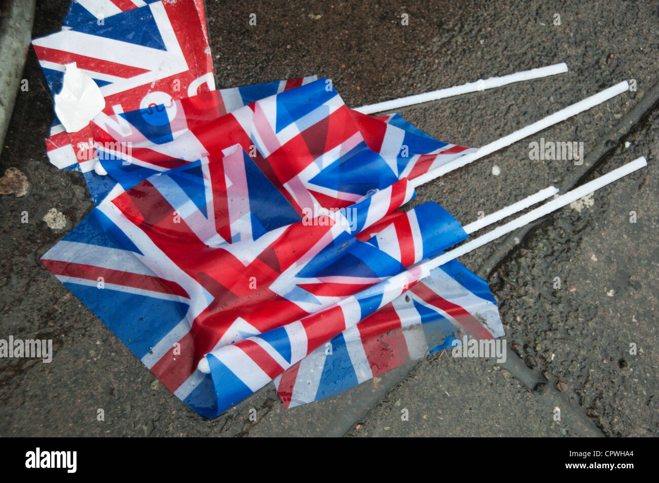 Queen Elizabeth Diamond Jubilee celebrations. Rain sodden Union Jack flags on the pavement. Stock Photo
