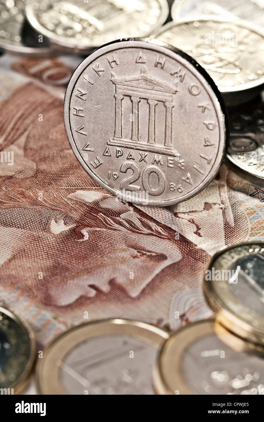 Greek drachma as coins and paper money. In the foreground € coins. Stock Photo