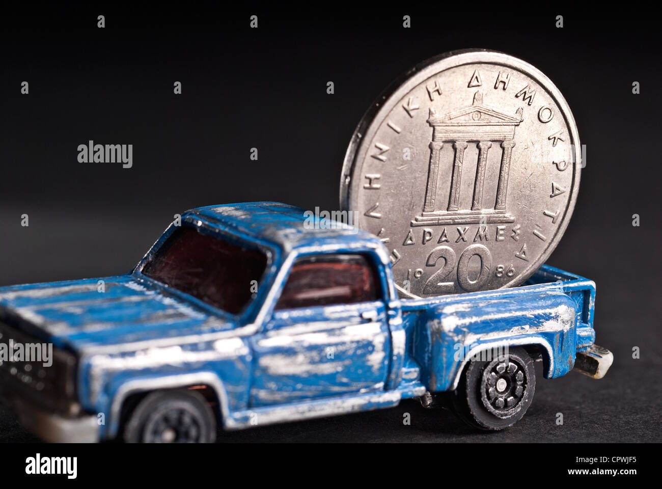 Old, worn-out pickup is very heavily loaded with Greek drachma. Stock Photo