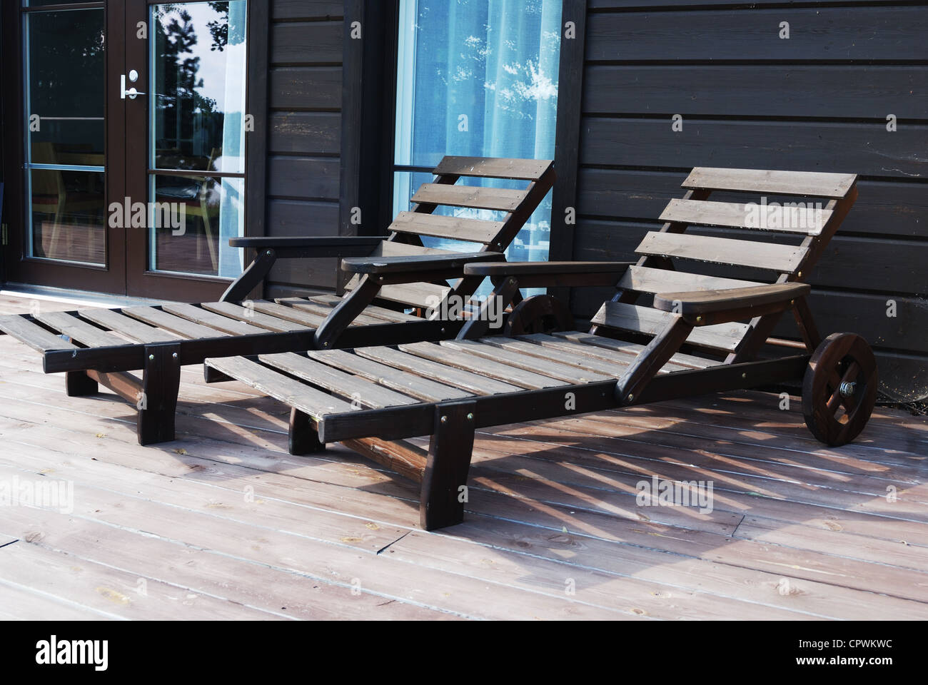 two wooden deck chairs on the terrace in summer Stock Photo - Alamy