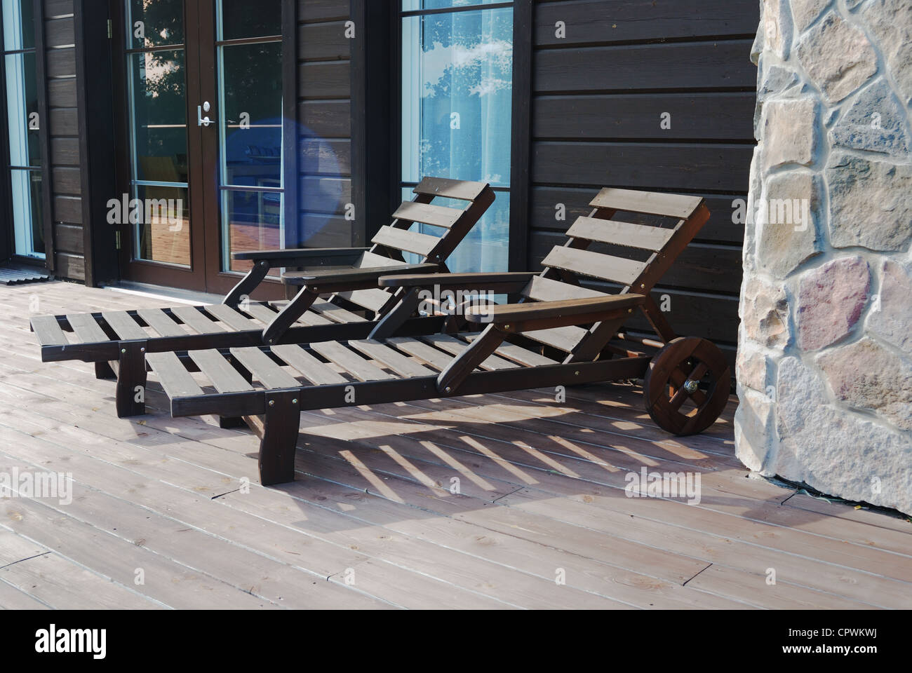 two wooden deck chairs on the terrace in summer Stock Photo - Alamy