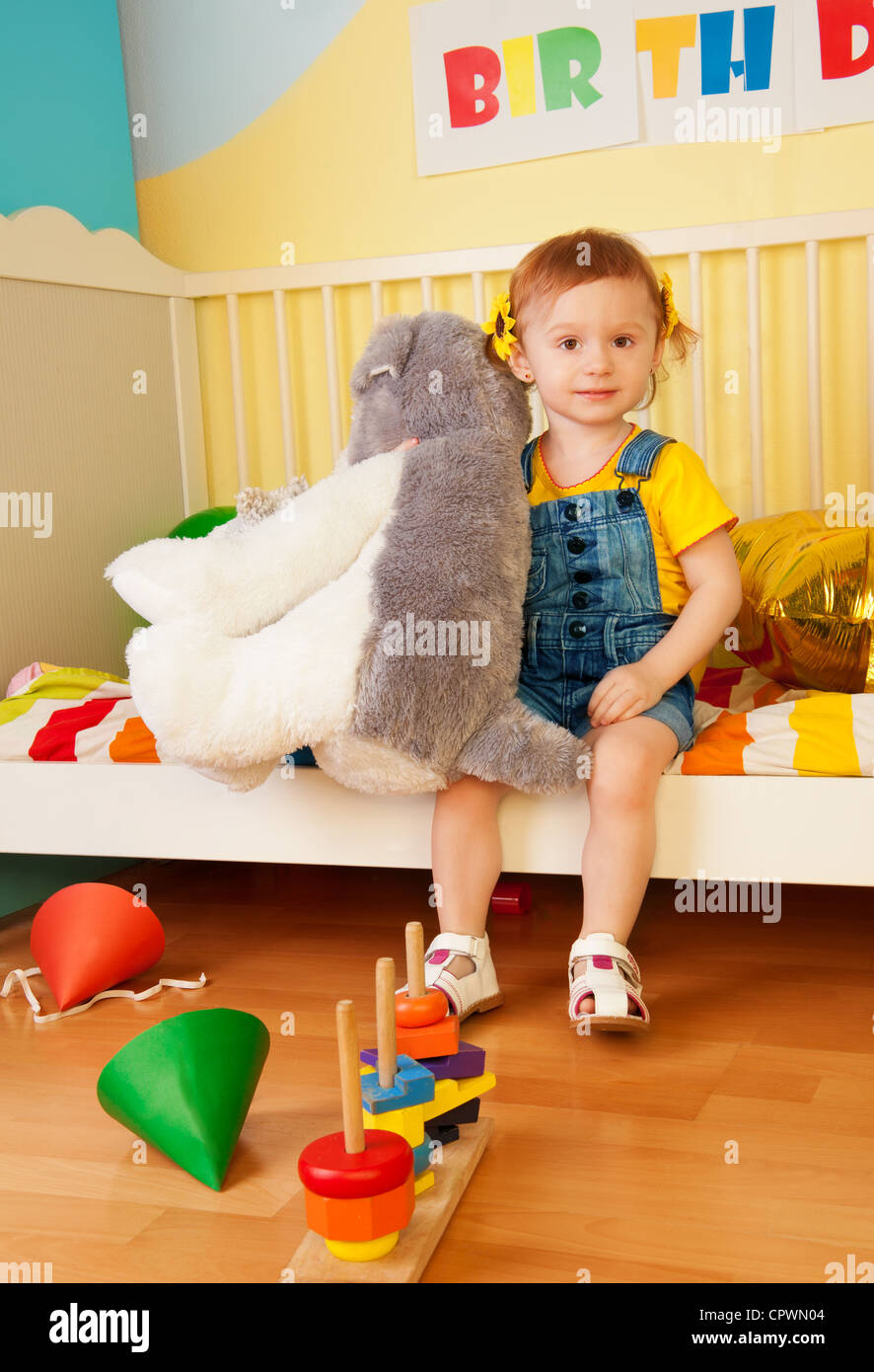 Girl sitting in the baby bed with boys looking at camera and smiling Stock Photo Alamy
