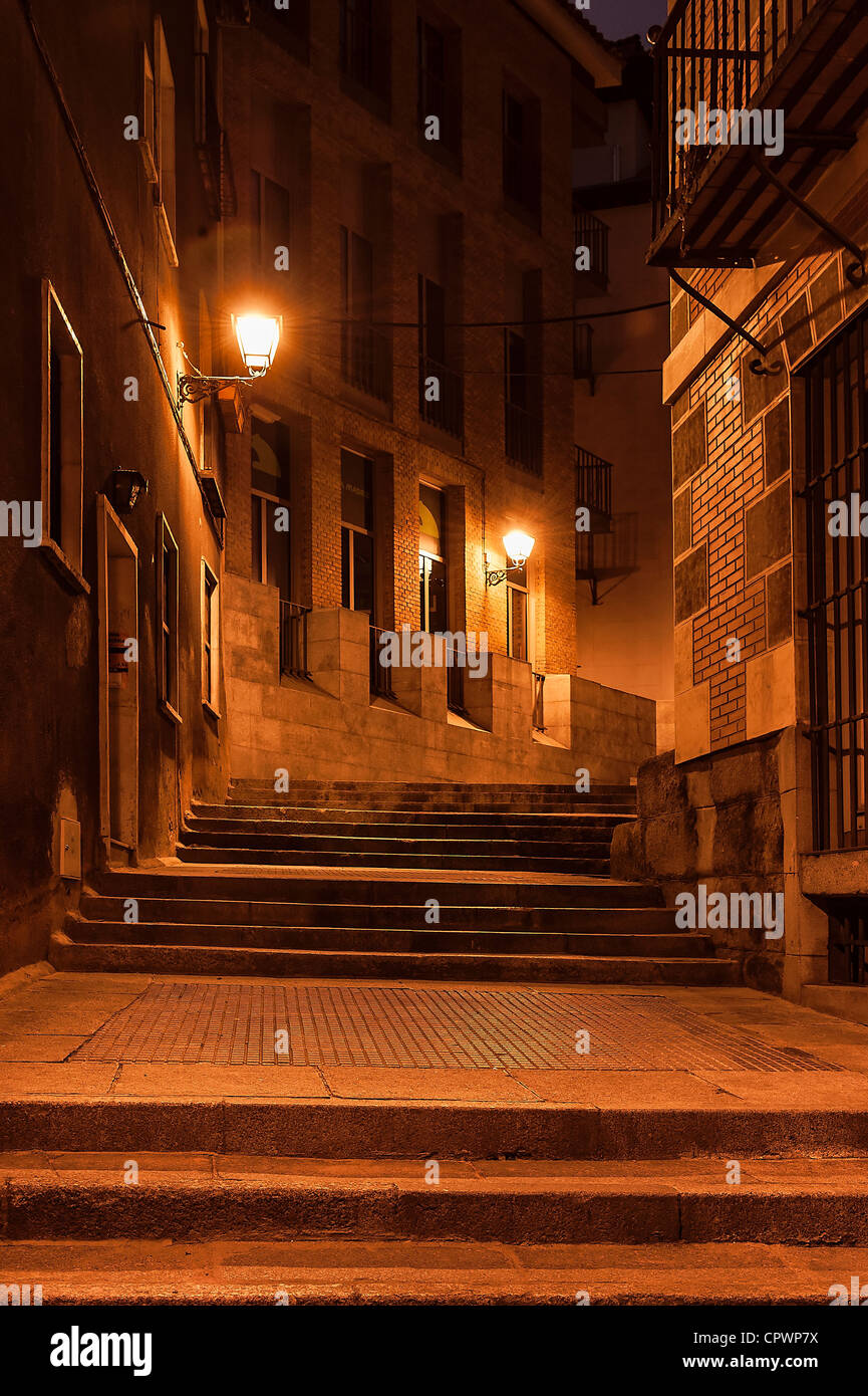 Narrow alley and steps illuminated by street lamps at night, Madrid, Spain Stock Photo