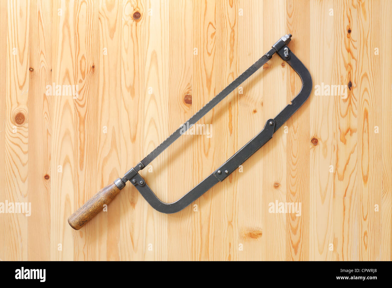 Old hacksaw on wooden surface Stock Photo