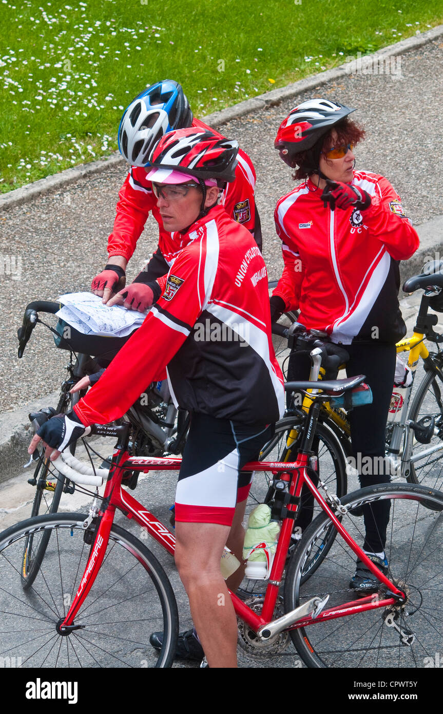 Three amateur sport cyclists looking at route directions - France. Stock Photo
