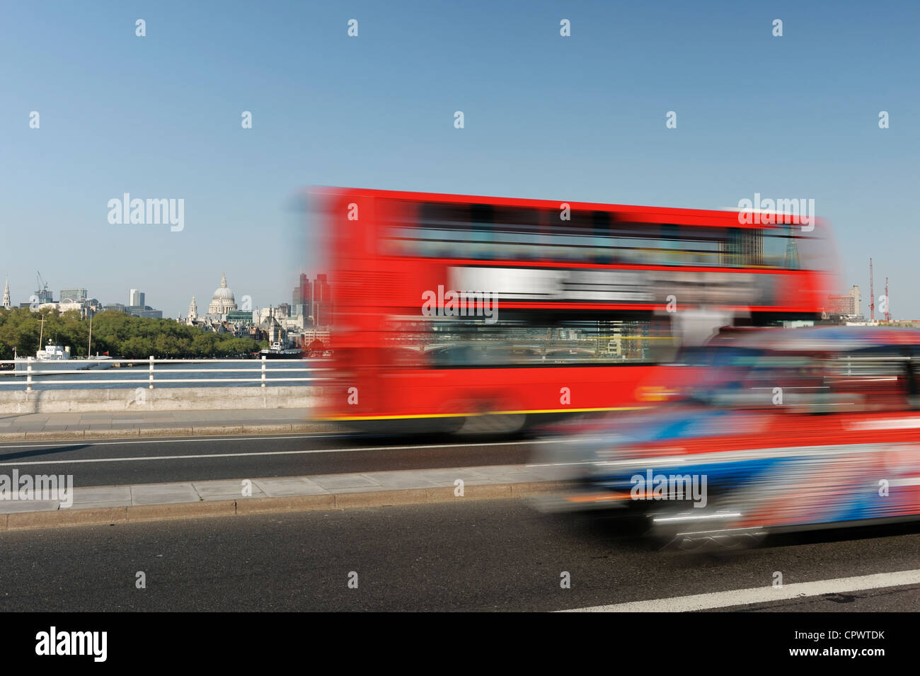 Traffic speeds along Waterloo bridge with the City of London skyline behind Stock Photo