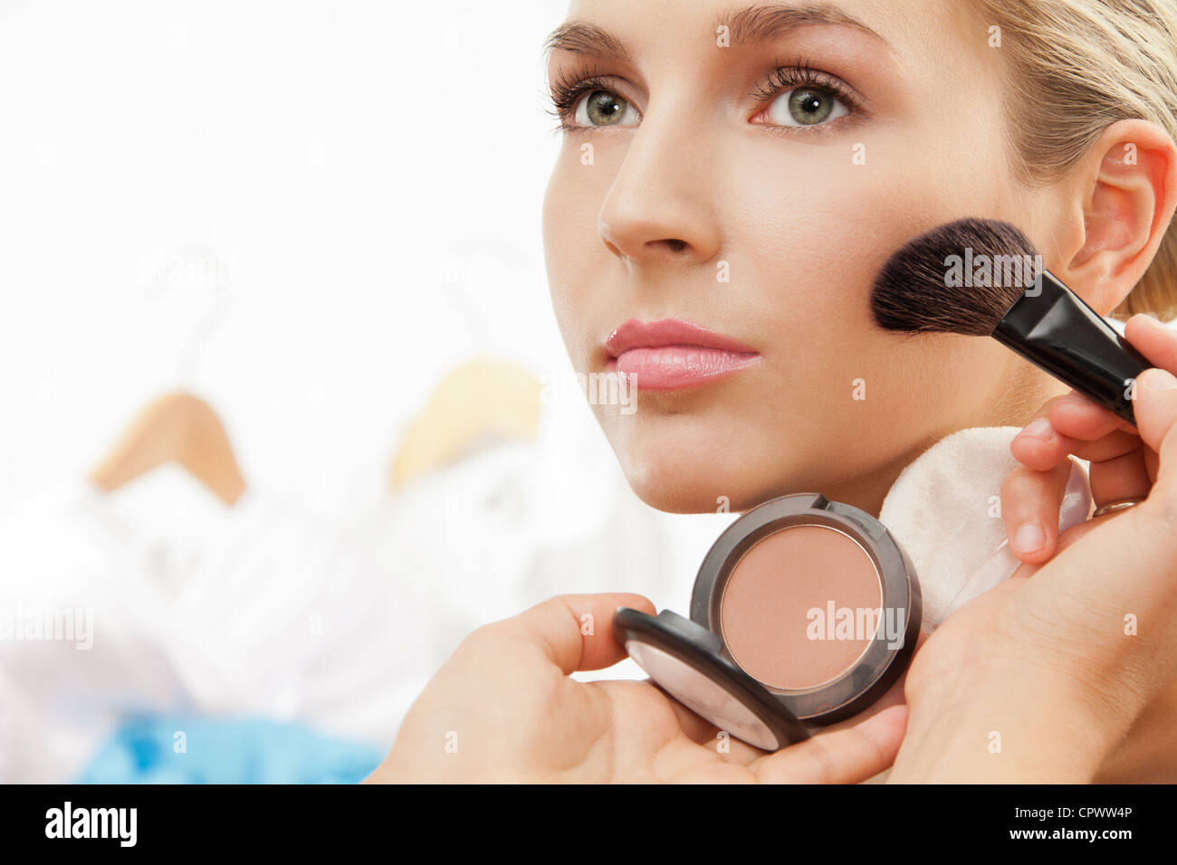 Using blush brush to apply blush on cheeks professional makeup artist