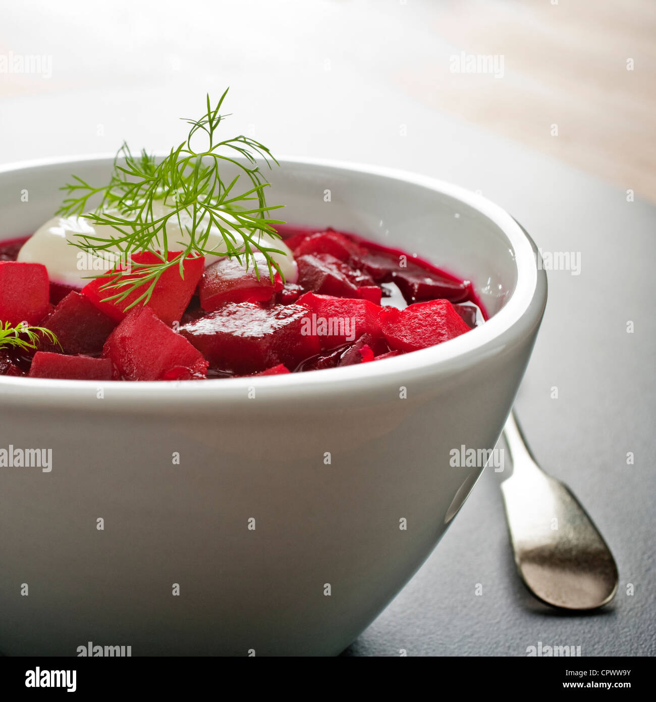 Traditional Russian soup borscht, made from beetroot, potatoes, onion, carrot and tomatoes, garnished with dill and sour cream. Stock Photo