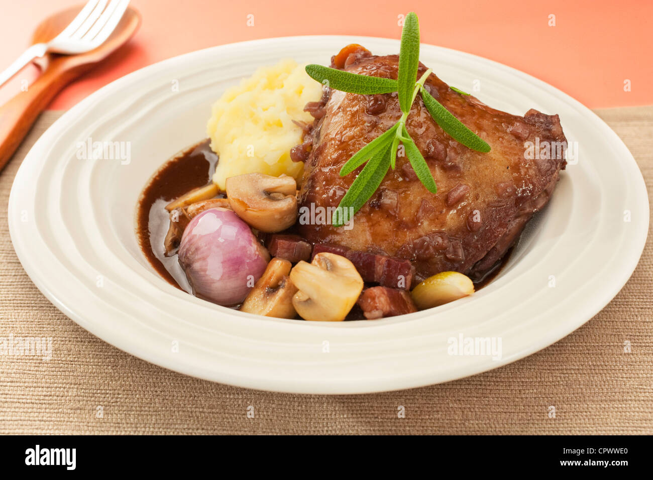 French classic, coq au vin or chicken in red wine with onions, mushrooms and bacon. Perfect for Sunday lunch with mashed potato. Stock Photo