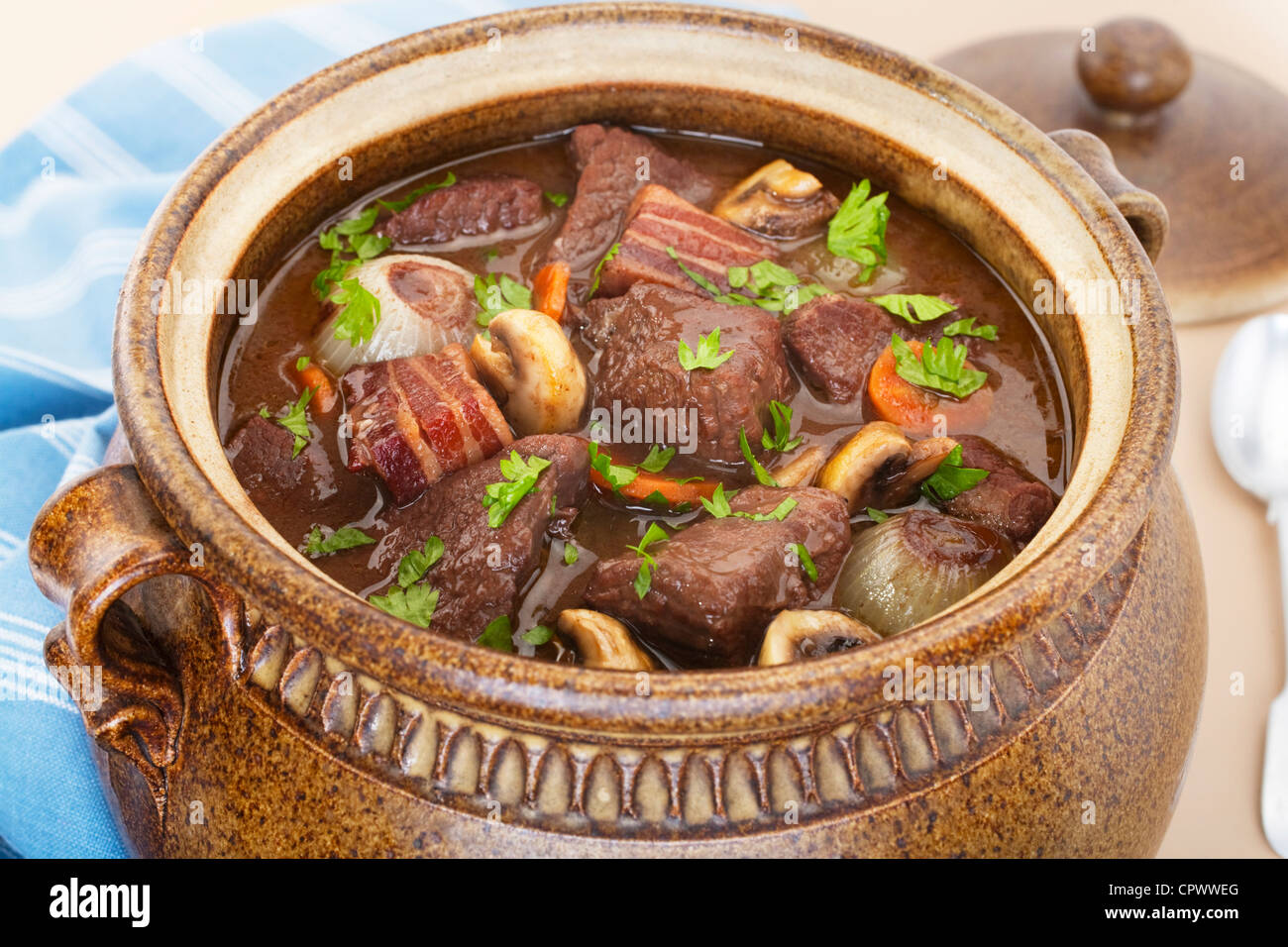 Classic beef bourguignon in a traditional brown pot. Stock Photo