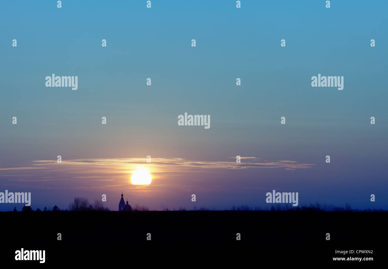 Sunset over the fields and the old Christian Church. Stock Photo