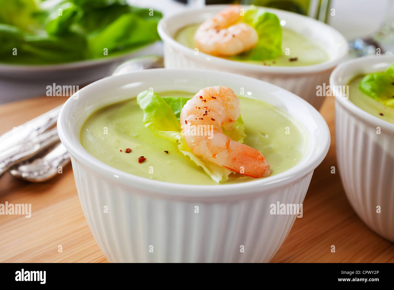 Avocado mousse in a ramekin, topped with prawn and lettuce. Stock Photo