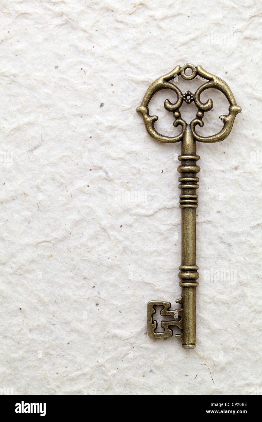 Antique key on handmade rice paper Stock Photo