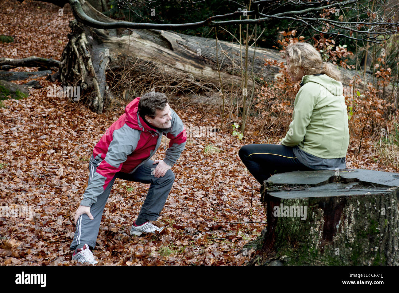 Mature couple performing warming up exercises in forest Stock Photo