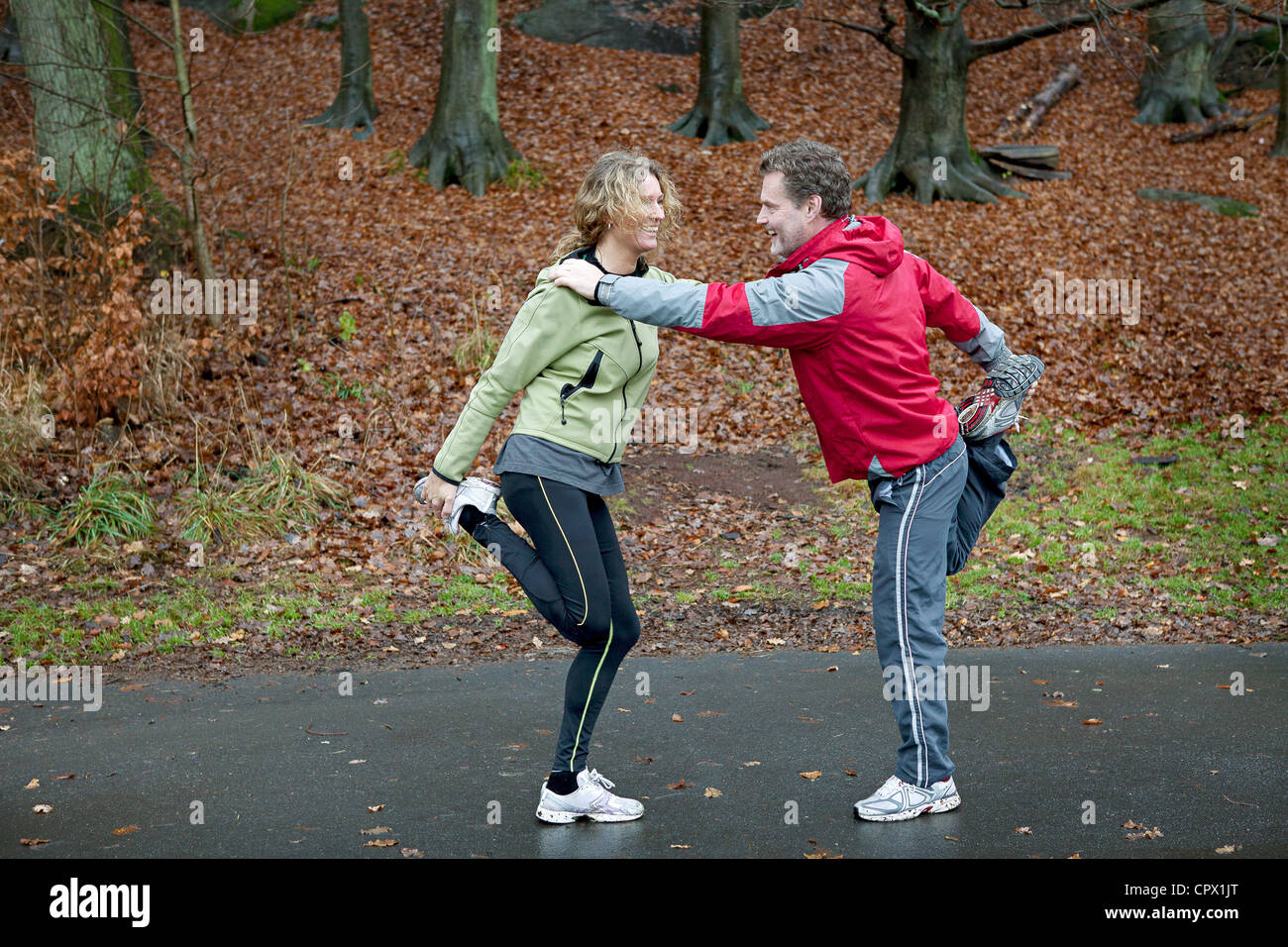 Mature couple leaning together to perform warming up exercises Stock Photo