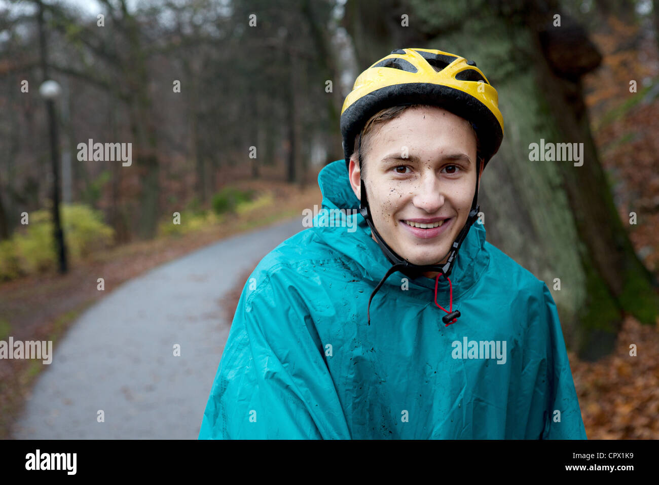 Young man wearing cycling helmet on forest path Stock Photo