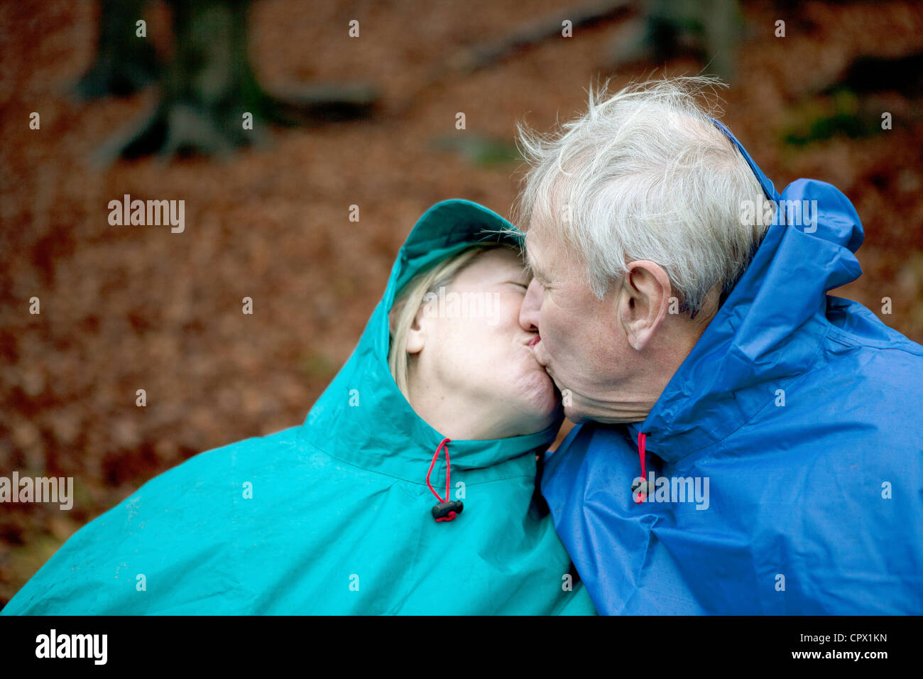 Senior couple wearing waterproofs and kissing Stock Photo