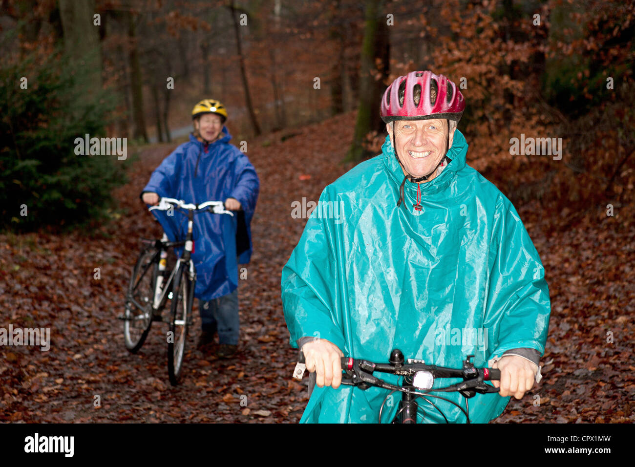 Senior couple cycling in forest Stock Photo