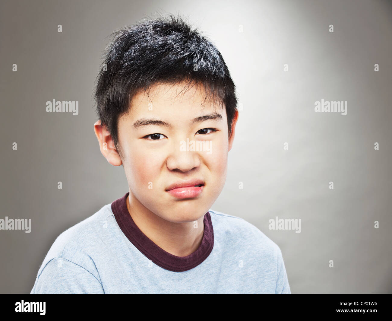 Portrait of grimacing young Asian teenage boy Stock Photo