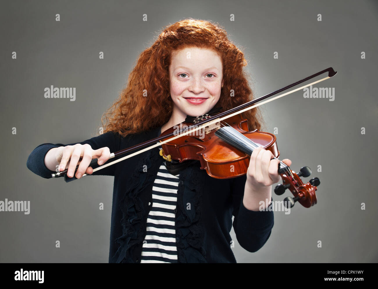 Portrait of mixed race teenage girl playing violin Stock Photo