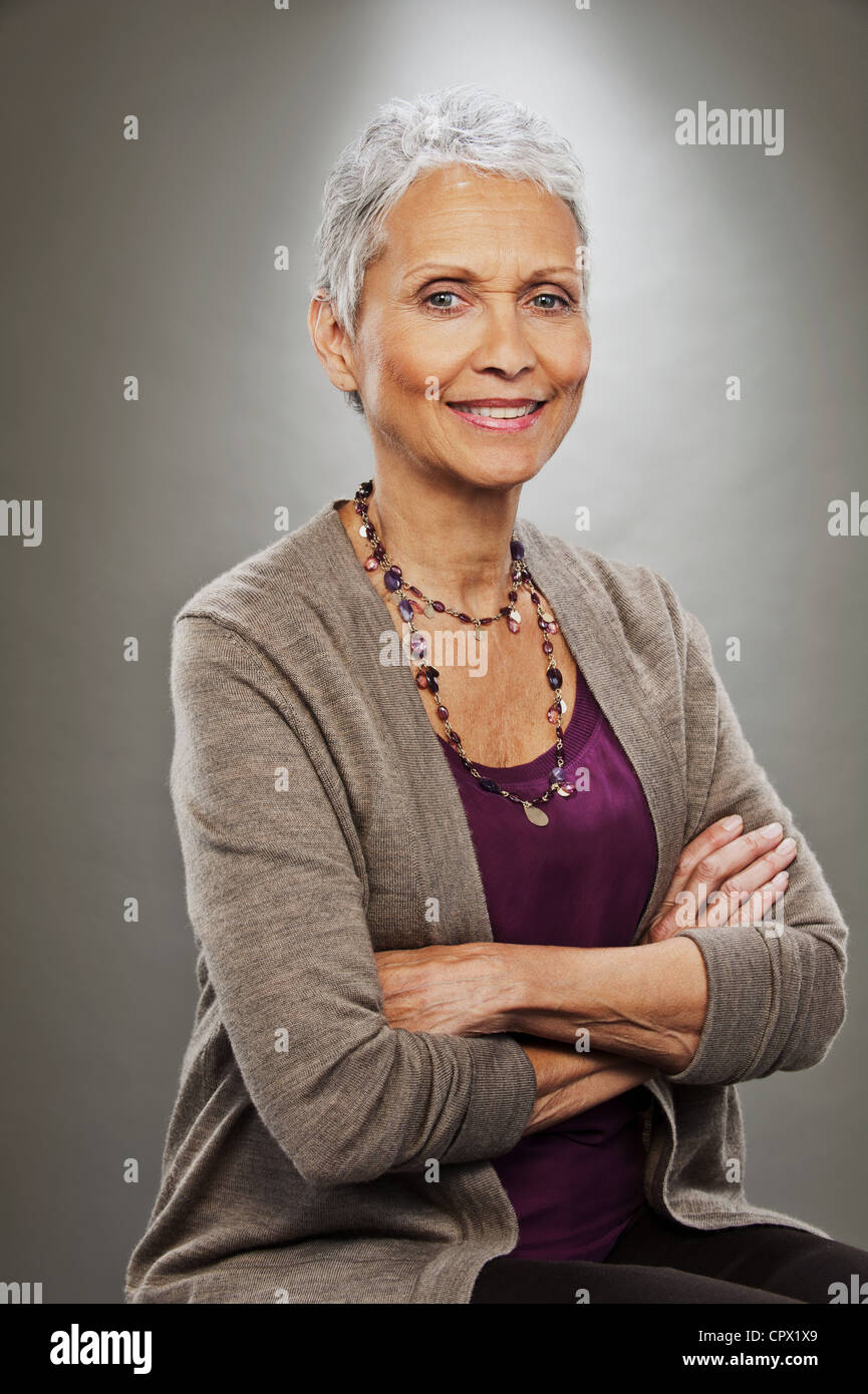 Portrait of senior woman smiling, studio shot Stock Photo