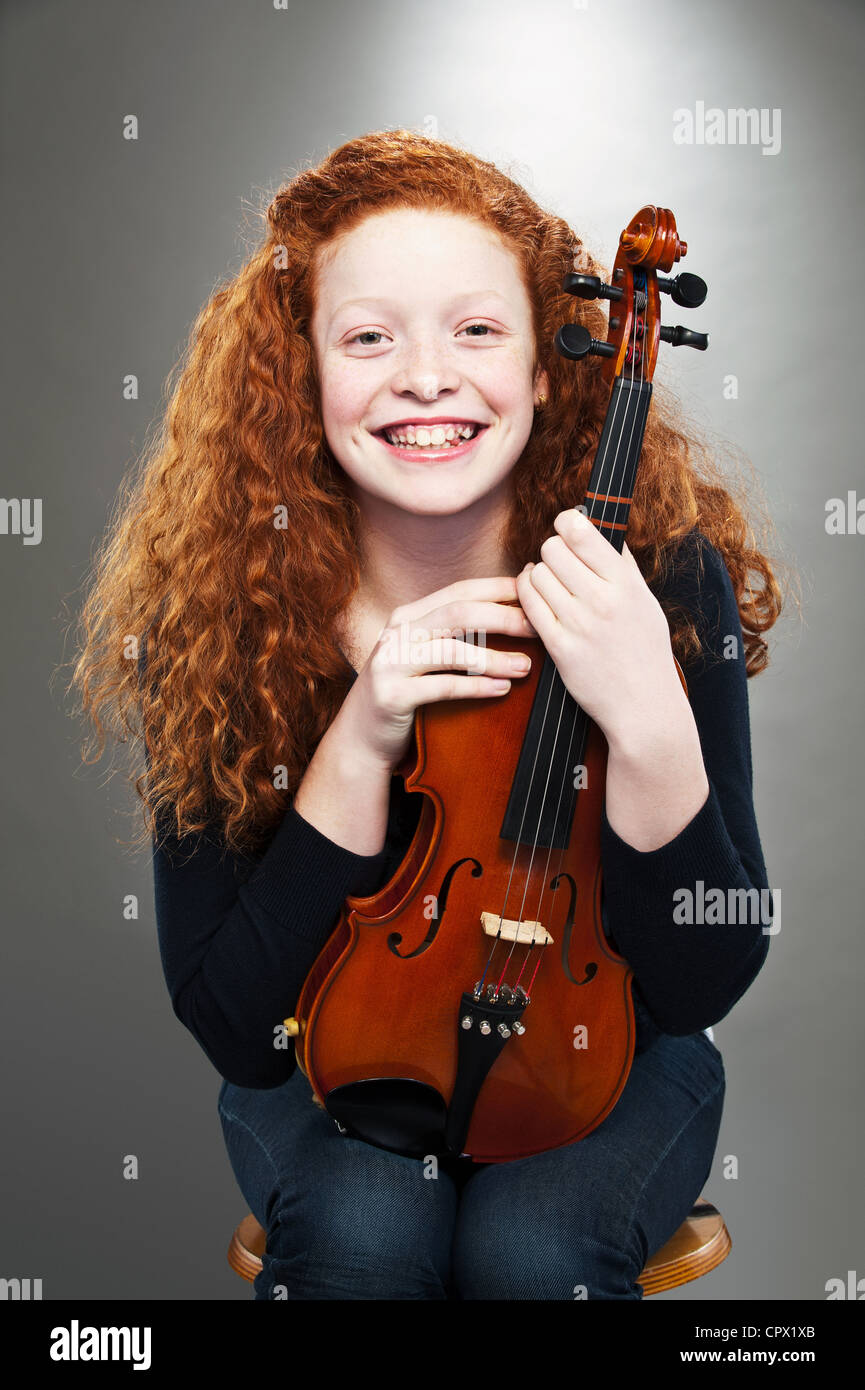 Portrait of mixed race teenage girl holding violin Stock Photo - Alamy