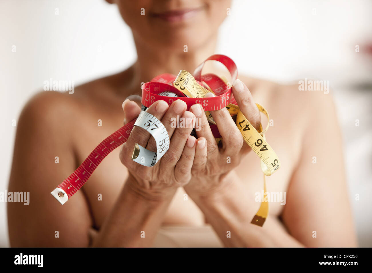 Senior woman holding measuring tapes in hands Stock Photo