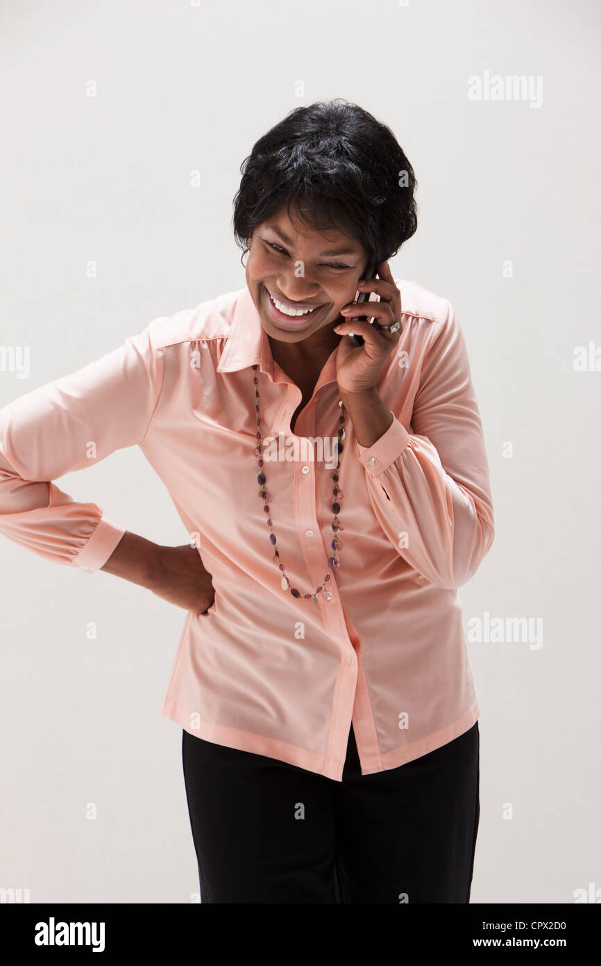 African American mature woman using cellphone, studio shot Stock Photo