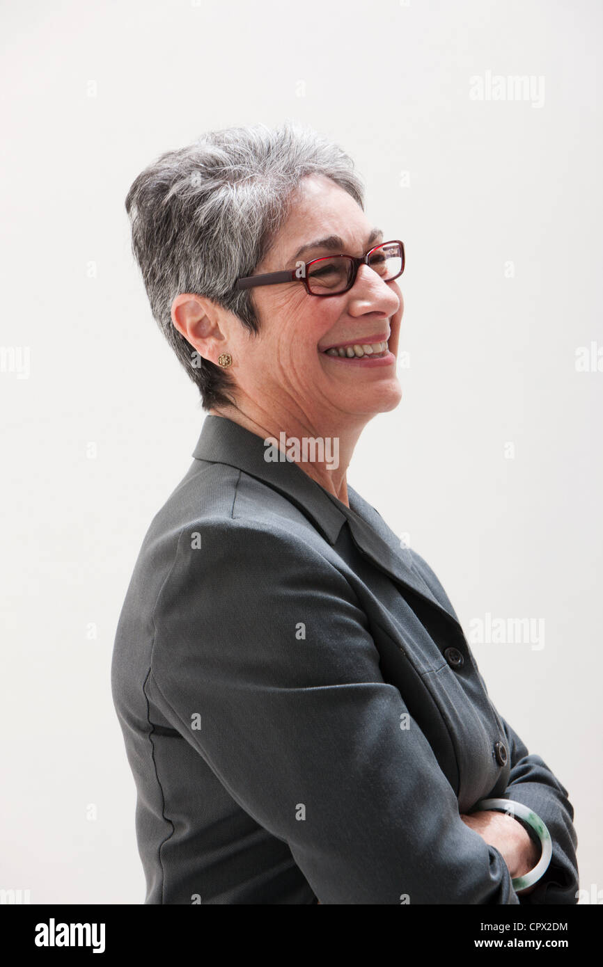 Mature businesswoman smiling, studio shot Stock Photo