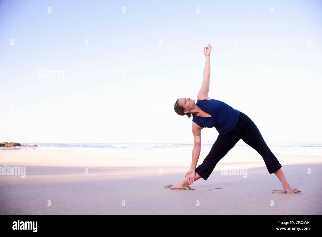 Woman doing yoga on beach, Playa Grande, Santa Cruz, Costa Rica Stock