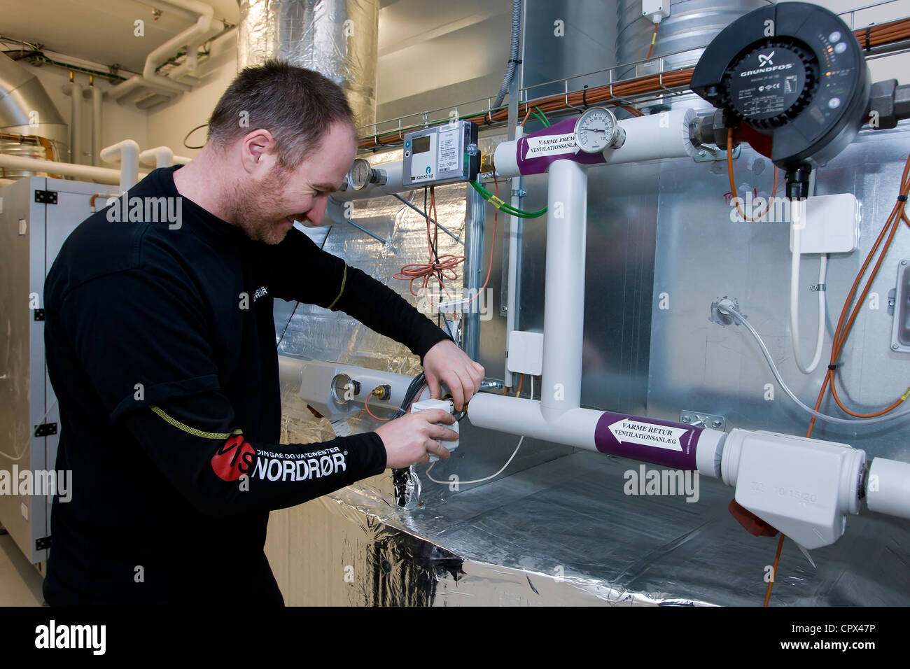 Heating and sanitary technician installs a engine valve Stock Photo Alamy