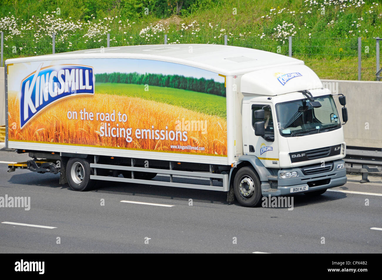 Advertising for Kingsmill bread a brand owned by Associated British Foods on side of streamlined delivery lorry truck with driver cab on UK motorway Stock Photo
