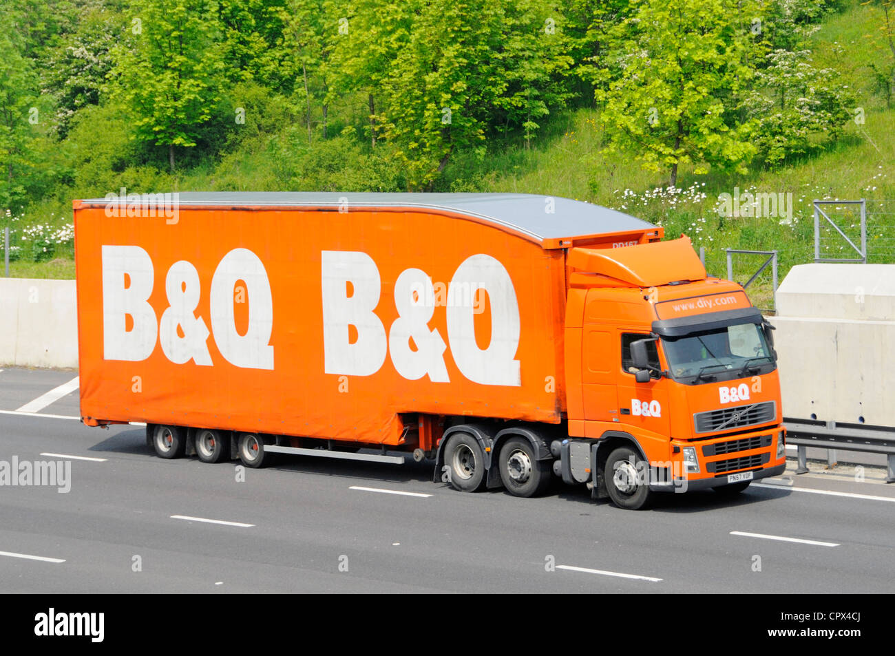 B&Q DIY retail & trade builders merchant business supply chain store delivery hgv lorry truck & side curtain trailer brand logo driving on UK motorway Stock Photo